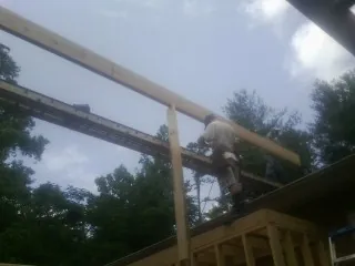 Carpenter setting a ridge beam over a new addition frame — Ice Dam Removal by Roofing Brothers in Agness