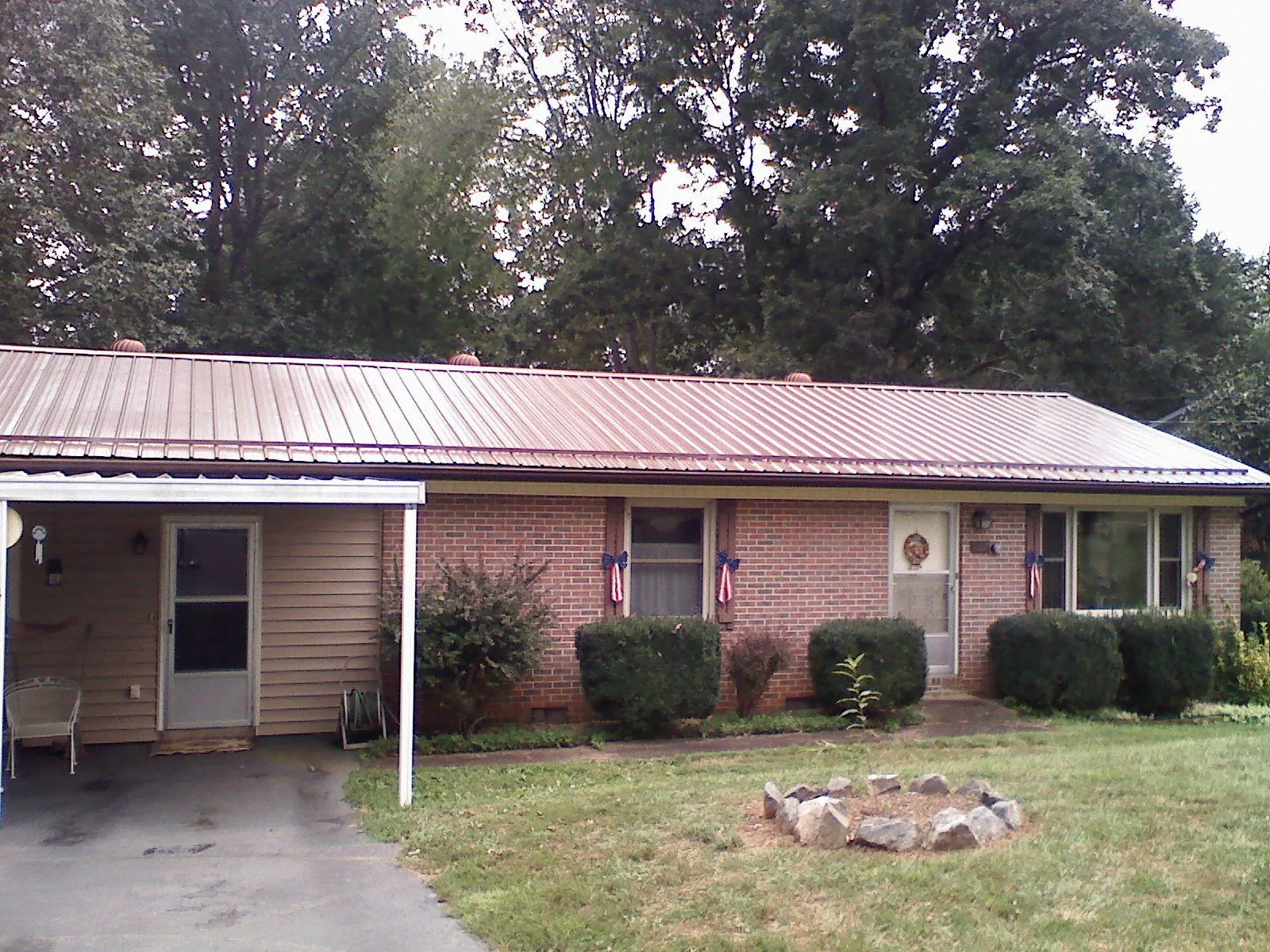 Bronze metal roof and carport on a brick ranch home — Roof Repair work by our crew in Agness