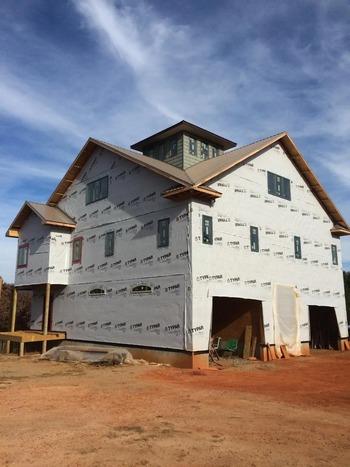 New two story house under construction with a cupola and gabled roofs in Agness